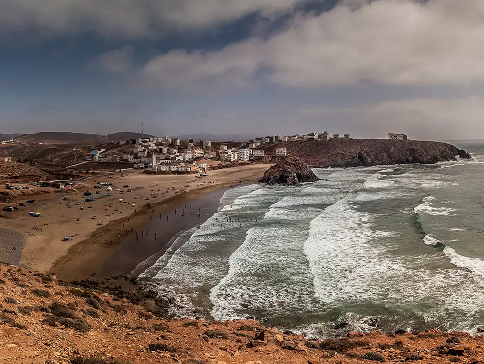 Wide sandy beach and rolling Atlantic waves at Plage Tamhrouchte.
