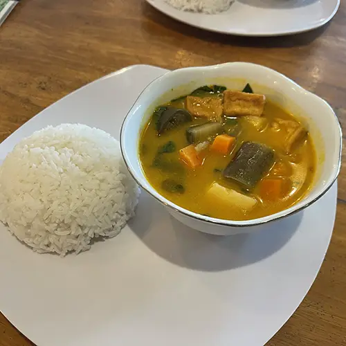 Bowl of vegan curry with tofu and vegetables served with rice in Mui Ne.