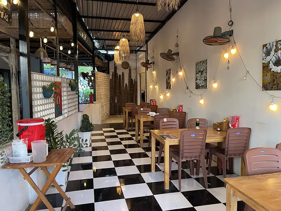 Dining room of a pure vegan restaurant in Mui Ne with wooden tables and warm lighting.