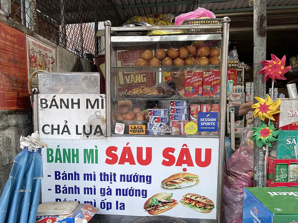 Street stall serving fresh baguettes and snacks along a busy sidewalk.