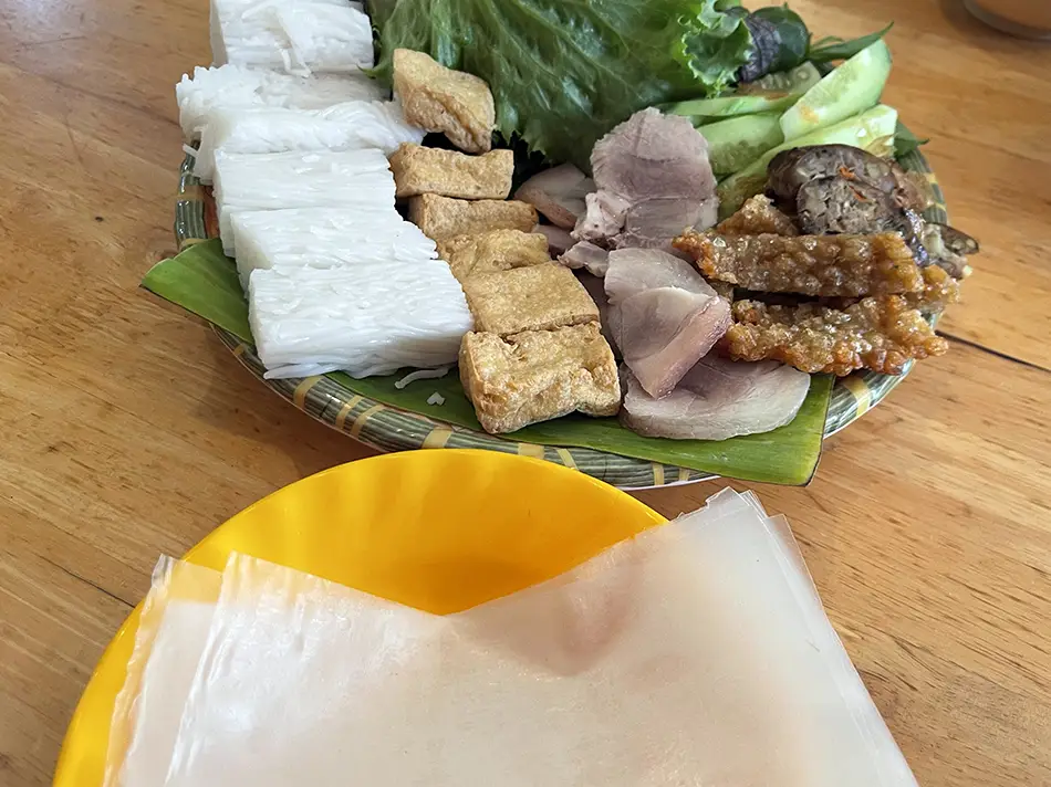 Traditional bun dau platter with pork, tofu, and fresh greens.