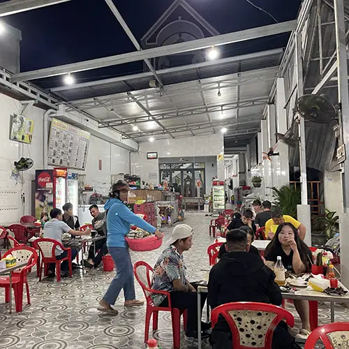 Indoor dining space in Mui Ne with metal tables and barbecue grills.