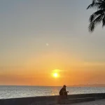 Sunset over a beach promenade.