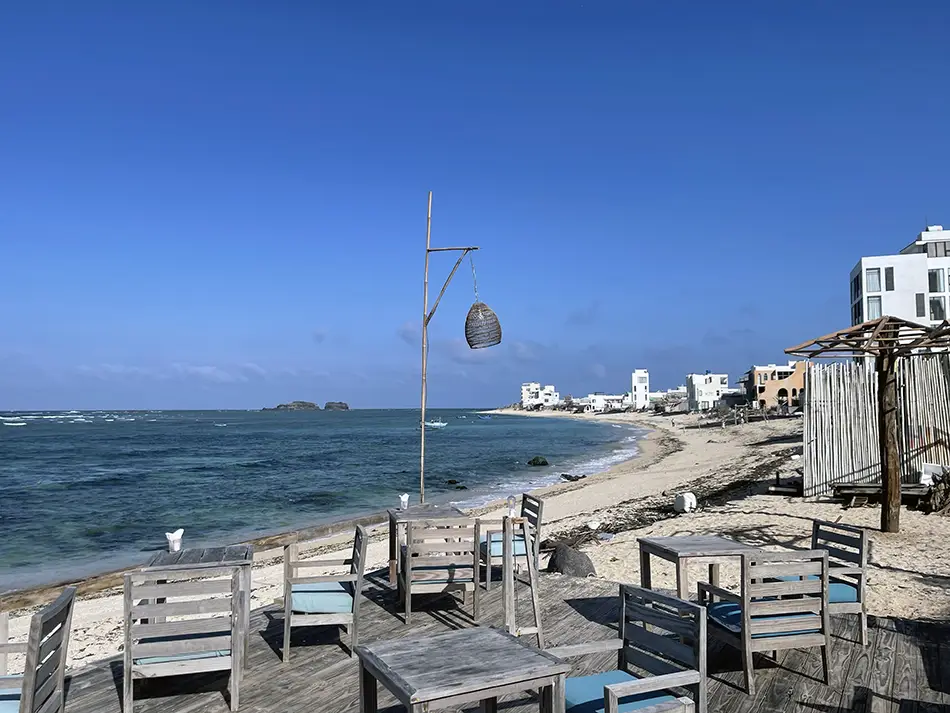 Seaside restaurant terrace on Phu Quy Island overlooking the ocean and coastal road.