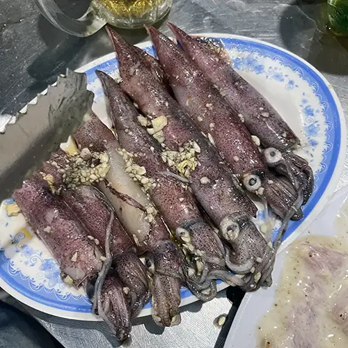 Grilled squid served with dipping sauce at one of the Best Places to Eat in Mui Ne.