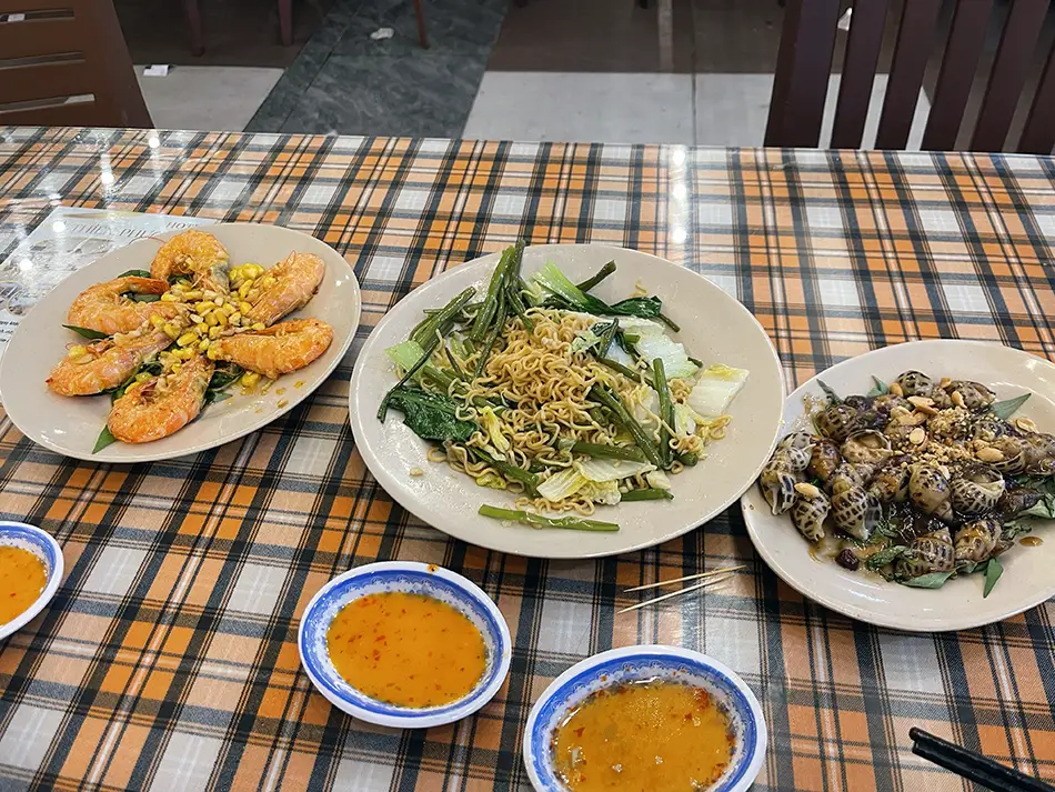 Assortment of fresh grilled seafood dishes on a table including shrimp and shellfish at a local restaurant