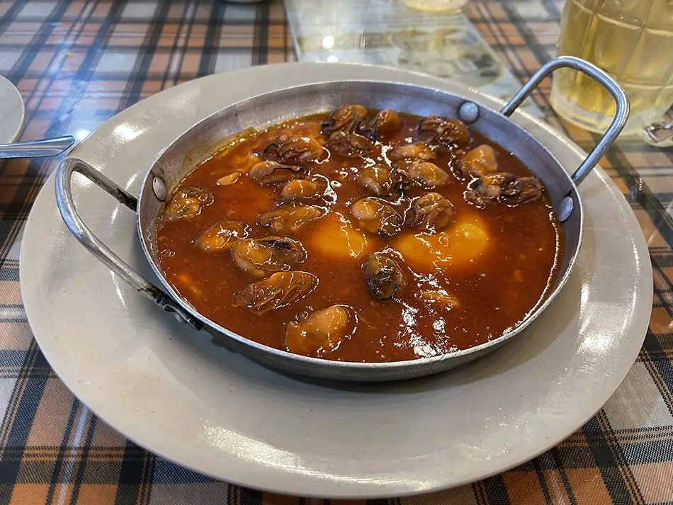 Sizzling cast-iron pan of hàu né with oysters in tomato sauce and eggs