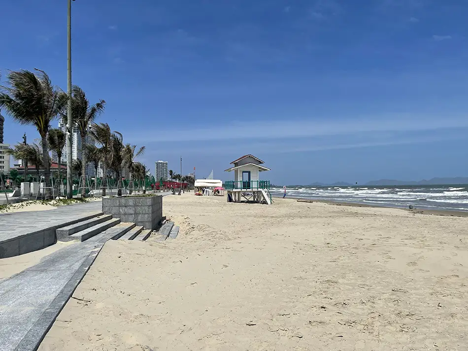 Long stretch of Back Beach (Bai Sau) seen from a palm-lined boardwalk.