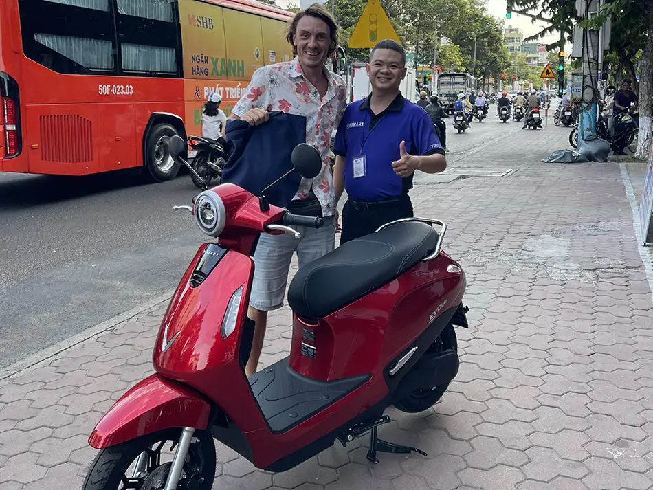 Yuriy Malykh with a Yamaha dealership consultant after buying a license free electric scooter in Vietnam.