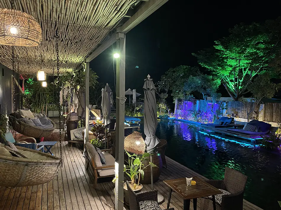 Cargo Remote boutique hotel terrace lit at night with lanterns, sun loungers, and pool