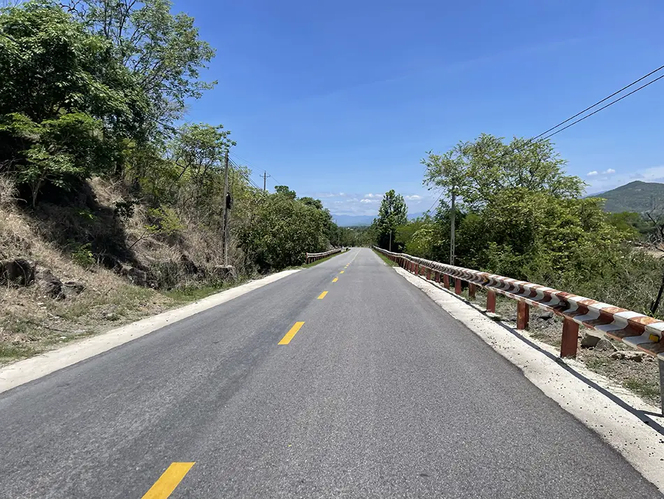 A scenic view of an empty road stretching between Cam Ranh and Da Lat.
