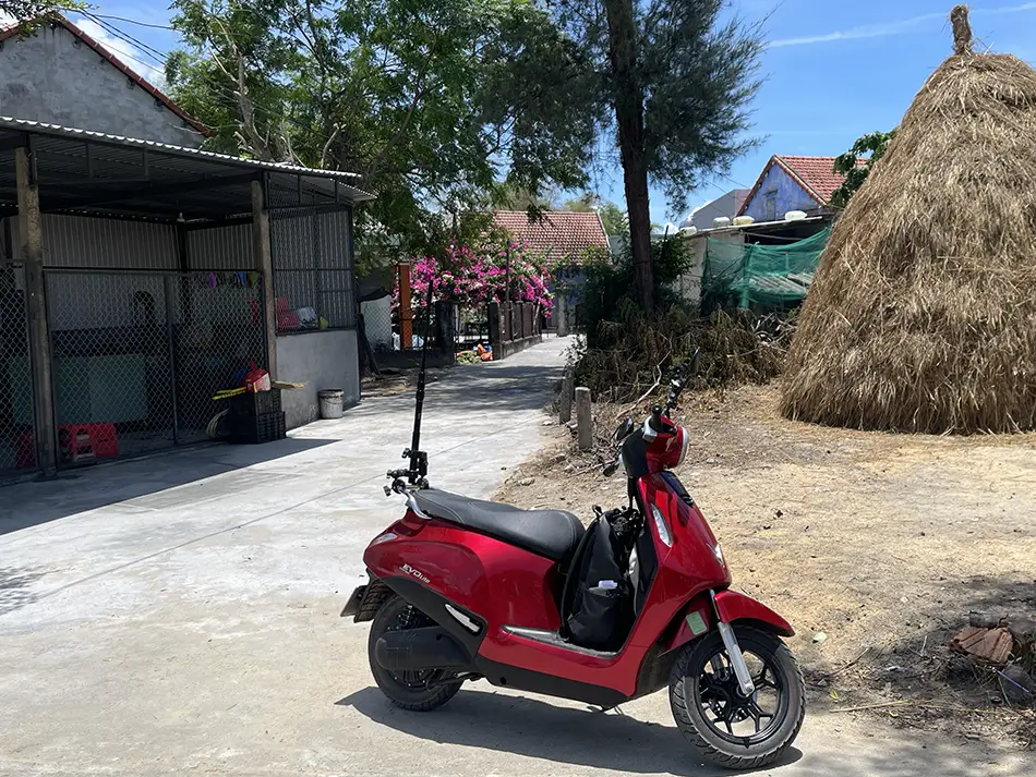 An electric scooter parked on a countryside road against the backdrop of a haystack in the suburbs of Hoi An.