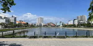Vung Tau lake with a wide concrete promenade and trees lining the path, the kind of urban scene visitors encounter on a Vung Tau day trip from Ho Chi Minh City.