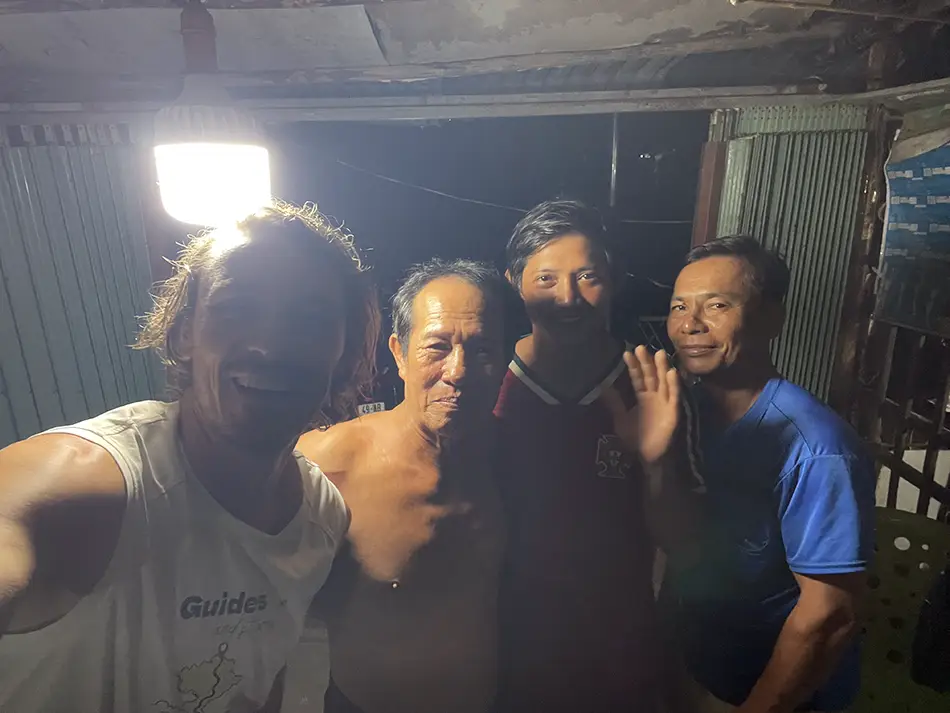 Traveler taking a night selfie with new friends during the Ca Mau stage of the Vietnam crossing diary.