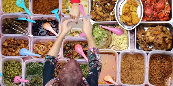 Overhead flat lay of Malaysia dishes: fried chicken, stir-fried noodles, spicy prawn curry
