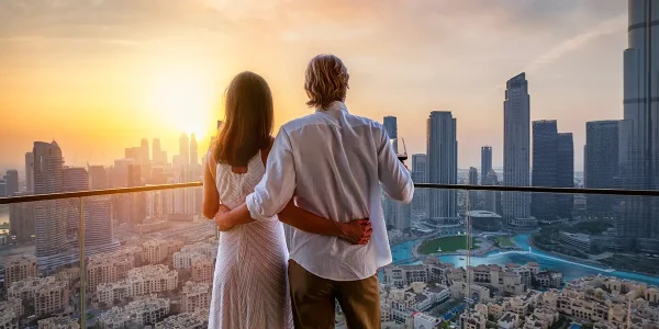 Romantic travel destinations represented with a couple standing on top of a skyscraper